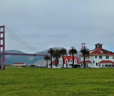 Golden Gate Bridge lit by the setting sun against the background of San Francisco skyline and beautiful cloudy sky